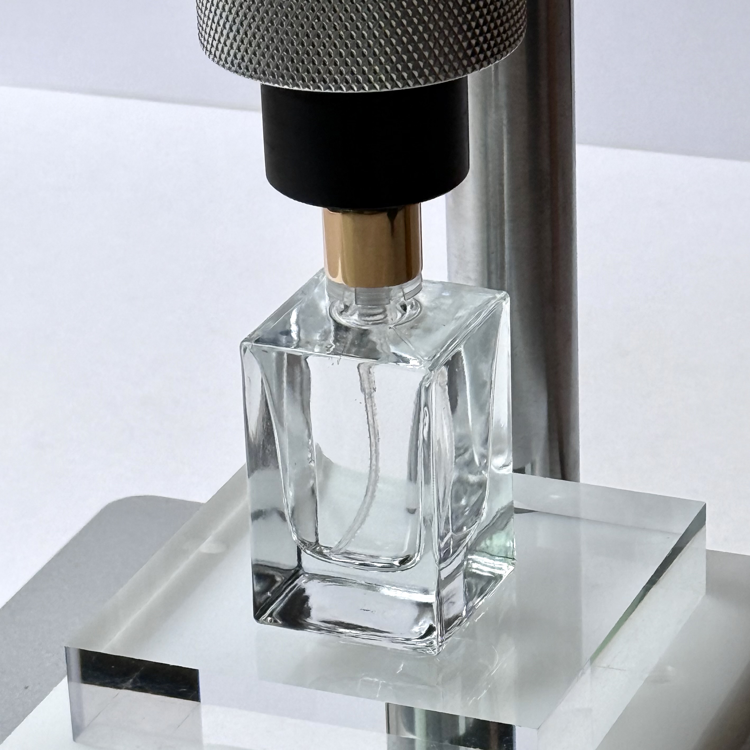 香水ボトルをアロマサーバーにセットして圧栓位置を合わせている様子